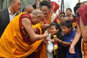 Его Святейшество Далай-лама приветствует детей по прибытию в Дорзонг Тубтен Донгак Рабгьял Чолинг для проведения церемонии освящения 12 сентября 2010. Фото: DIIR