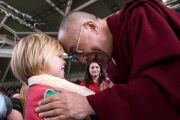 Его Святейшество Далай-лама здоровается с маленьким мальчиком перед публичной лекцией. Брисбен, Австралия. 15 июня 2011. Фото: Rusty Stewart/DLAIL