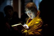 Его Святейшество Далай-лама читает молитвы при свете фонарика в сумраке Тородо (зала светильников) в Окуно-ин. Коясан, Япония. 1 ноября 2011. Фото: Тензин Чойджор (Офис ЕСДЛ)