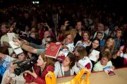 Люди передают на сцену книги, чтобы получить автограф Его Святейшество Далай-ламы во время встречи "Мир и всеобщая ответственность". Зальцбург, Австрия. 21 мая 2012 г. Фото: Тензин Чойджор (Офис ЕСДЛ)