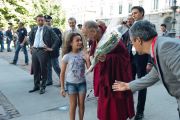 Девочка дарит цветы Его Святейшеству Далай-ламу по прибытии в мэрию Милана, Италия. 26 июня 2012 г. Фото: Тензин Чойджор (Офис ЕСДЛ)