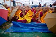 Монахи внимают учениям Его Святейшества Далай-ламы в парке Норлинг под проливным дождем. Тибетское поселение Декьилинг неподалеку от г. Дехрадун, Индия. 14 сентября 2012 г. Фото: Тензин Чойджор (Офис ЕСДЛ)