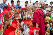 Его Святейшество Далай-лама приветствует учеников, принимавших участие в праздничном концерте по случаю юбилея фонда "Тибетские дома" в Массури, Индия. 17 сентября 2012 г. Фото: Тензин Чойджор (Офис ЕСДЛ)