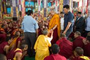 Его Святейшество Далай-лама проходит через толпу монахов, направляясь на  учения по 18 коренным текстам и комментариям традиции Ламрим в монастыре Дрепунг Лоселинг. 8 декабря 2012. Мандгод, Индия. Фото: Манюэль Бауэр