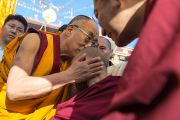 Его Святейшество Далай-лама здоровается с монахом в монастыре Дрепунг Лоселинг, где проходили торжества по случаю 23-летия вручения Далай-ламе Нобелевской премии мира. Мандгод, Индия. 10 декабря 2012 г. Фото: Тензин Чойджор (офис ЕСДЛ)