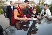 Его Святейшество Далай-лама подписывает фотографии по окончании посещения швейцарского парламента. Берн, Швейцария. 16 апреля 2013 г. Фото: Manuel Bauer
