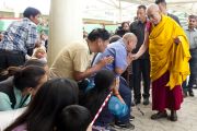 Его Святейшество Далай-лама приветствует своих последователей по пути в главный тибетский храм Дхарамсалы перед началом первого дня учений, которые он дарует по просьбе группы буддистов из Индии. Дхарамсала, штат Химачал-Прадеш, Индия. 1 июня 2013 г. Фото: Абхишек Мадхукар