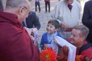 Его Святейшество Далай-лама беседует с незрячим мальчиком по дороге к месту проведения лекции «Культура сострадания». Рига, Латвия. 9 сентября 2013 г. Фото: Джереми Рассел (Офис ЕСДЛ)
