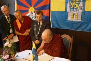 Его Святейшество Далай-лама с мэром Вунсторфа Рольфом-Акселем Эберхардтом (слева) оставляет запись в гостевой книге в Вунстрофской ратуше в Вунсторфе, Германия, 19 сентября 2013 г. Фото: Джереми Рассел (Офис ЕСДЛ)
