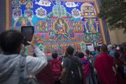 Участники учений Его Святейшества Далай-ламы разглядывают огромную танку Гуру Ринпоче, выполненную в технике аппликации, вывешенную в монастыре Сера Чже. Билакуппе, штат Карнатака, Индия. 29 декабря 2013 г. Фото: Тензин Чойджор (офис ЕСДЛ)