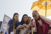 Его Святейшество Далай-лама по традиции зажигает светильник перед началом своего выступления на стадионе им. Неру. Гувахати, штат Ассам, Индия. 2 февраля 2014 г. Фото: Тензин Чойджор (офис ЕСДЛ)