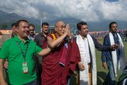 Его Святейшество Далай-лама машет рукой толпе болельщиков, покидая стадион Ассоциации крикета штата Химачал-Прадеш после матча между сборными Индии и Вест-Индии. Дхарамсала, Индия. 17 октября 2014 г. Фото: Тензин Чойджор (офис ЕСДЛ)