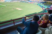 Его Святейшество Далай-лама наблюдает за матчем по крикету сборных Индии и Вест-Индии на стадионе Ассоциации крикета штата Химачал-Прадеш. Дхарамсала, Индия. 17 октября 2014 г. Фото: Тензин Чойджор (офис ЕСДЛ)