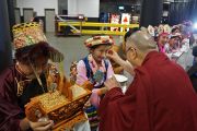Его Святейшество Далай-лама стирает слезу радости со щеки тибетской девочки, приветствующей духовного лидера в спортивном комплексе "ТД-Гарден" перед началом лекции "Образование для сердца и ума". Бостон, штат Массачусетс, США. 1 ноября 2014 г. Фото: Джереми Рассел (офис ЕСДЛ)