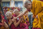 Его Святейшество Далай-лама здоровается с пожилым монахом по окончании третьего дня учений в монастыре Ганден Джангце. Мундгод, Индия. 25 декабря 2014 г. Фото: Тензин Чойджор (офис ЕСДЛ)