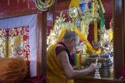 Его Святейшество Далай-лама зажигает масляный светильник во время посещения землячества Дхокханг монастыря Ганден. Мундгод. Индия. 28 декабря 2014 г. Фото: Тензин Чойджор (офис ЕСДЛ)