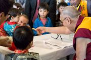 Его Святейшество Далай-лама угощает конфетами детей на встрече с тибетцами, живущими в Дании и соседних странах. Копенгаген, Дания. 10 февраля 2015 г. Фото: Джереми Рассел (офис ЕСДЛ).