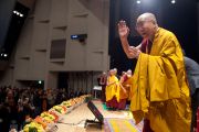 Его Святейшество Далай-лама приветствует аудиторию в начале второго дня учений в университете Шова Джоси. Токио, Япония. 13 апреля 2015 г. Фото: Тензин Джигме