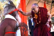 Его Святейшество Далай-лама обращается к одному из танцоров, приветствовавших его, со словами: "Я хочу увидеть ваш нос". Улуру, Северная Территория, Австралия. 13 июня 2015 г. Фото: Расти Стюарт