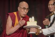 Его Святейшество Далай-лама задувает свечи на именинном торте, который ему преподнесли в театре Аннахайма на церемонии провозглашения Гарден-Гроув и Вестминстера городами сострадания. Аннахайм, штат Калифорния, США. 5 июля 2015 г. Фото: Тензин Чойджор (офис ЕСДЛ)