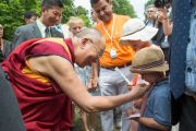 Его Святейшество Далай-лама здоровается со своим юным поклонником в висбаденском Курпарке. Висбаден, Гессен, Германия. 12 июля 2015 г. Фото: Мануэль Бауэр