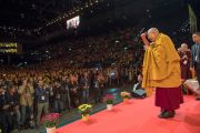 Его Святейшество Далай-лама приветствует слушателей, поднявшись на сцену стадиона Халлен. Цюрих, Швейцария. 14 октября 2016 г. Фото: Мануэль Бауэр