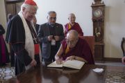 Его Святейшество Далай-лама расписывается в книге почетных гостей во время визита в резиденцию кардинала Милана Анджело Сколы. Милан, Италия. 20 октября 2016 г. Фото: Тензин Чойджор (офис ЕСДЛ)