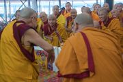 Его Святейшество Далай-лама приветствует монахов, сидящих на сцене, в начале первого дня учений, предваряющих посвящение Калачакры. Бодхгая, штат Бихар, Индия. 5 января 2017 г. Фото: Тензин Чойджор (офис ЕСДЛ)