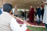 По прибытии на место учений, организованных по просьбе фонда «Видьялока», Его Святейшество Далай-лама останавливается, чтобы послушать музыканта, исполняющего на флейте прекрасную мелодию. Нью-Дели, Индия. 4 февраля 2017 г. Фото: Тензин Чойджор (офис ЕСДЛ)