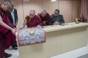 Его Святейшество Далай-лама подписывает традиционную танку с изображением Будды Шакьямуни и 17 пандит Наланды, преподнесенную им в дар университету Нава Наланда Махавихара. Раджгир, штат Бихар, Индия. 18 марта 2017 г. Фото: Тензин Чойджор (офис ЕСДЛ)