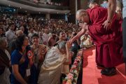 Его Святейшество Далай-лама приветствует слушателей, поднявшись на сцену центра исполнительских искусств Индийской телевизионной академии (ИТА). Гувахати, штат Ассам, Индия. 1 апреля 2017 г. Фото: Тензин Чойджор (офис ЕСДЛ)