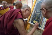 Его Святейшество Далай-лама подписывает постер в знак открытия Гималайского буддийского семинара, организованного в монастыре Тхупсунг Дхаргьелинг. Диранг, штат Аруначал-Прадеш, Индия. 5 апреля 2017 г. Фото: Тензин Чойджор (офис ЕСДЛ)