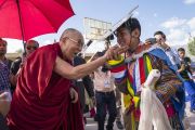 Его Святейшество Далай-лама шутливо приветствует юного танцора по прибытии в Тибетскую детскую деревню S.O.S в Чогламсаре. Ле, Ладак, штат Джамму и Кашмир, Индия. 25 июля 2017 г. Фото: Тензин Чойджор (офис ЕСДЛ)