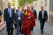 По дороге к машине Его Святейшество Далай-лама машет рукой местным жителям, выглядывающим из окон, чтобы увидеть тибетского духовного лидера. Пиза, Италия. 20 сентября 2017 г. Фото: Olivier Adam.