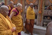 Паломники выглядывают из-за каменной ограды в надежде хоть мельком увидеть Его Святейшество Далай-ламу, совершающего обход вокруг храма Махабодхи. Бодхгая, штат Бихар, Индия. 2 января 2018 г. Фото: Тензин Чойджор.