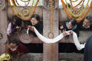 Паломники выглядывают из-за каменной ограды в надежде хоть мельком увидеть Его Святейшество Далай-ламу, совершающего обход вокруг храма Махабодхи. Бодхгая, штат Бихар, Индия. 13 января 2018 г. Фото: Тензин Чойджор.