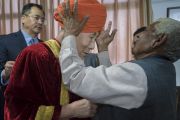 Его Святейшеству Далай-ламе помогают надеть традиционный тюрбан перед началом 1-й церемонии вручения дипломов в Центральном университете Джамму. Джамму, штат Джамму и Кашмир, Индия. 18 марта 2018 г. Фото: Тензин Чойджор.