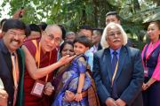 Его Святейшество Далай-лама фотографируется с маленькой девочкой, направляясь на обед по завершении торжественного открытия 92-й ежегодной встречи Ассоциации индийских университетов. Сарнатх, штат Уттар-Прадеш, Индия. 19 марта 2018 г. Фото: Лобсанг Церинг.