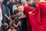 Его Святейшество Далай-лама шутливо приветствует детей во время встречи с туристами в главном тибетском храме. Дхарамсала, Индия. 19 мая 2018 г. Фото: Тензин Чойджор.