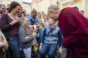 Покидая Вильнюсский университет по завершении публичной лекции, Его Святейшество Далай-лама останавливается, чтобы его сфотографировала маленькая девочка. Вильнюс, Литва. 13 июня 2018 г. Фото: Тензин Чойджор.