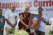Его Святейшество Далай-лама держит свой портрет, преподнесенный ему по завершении церемонии запуска учебной программы «Счастье» для школ Дели. Нью-Дели, Индия. 2 июля 2018 г. Фото: Тензин Чойджор.